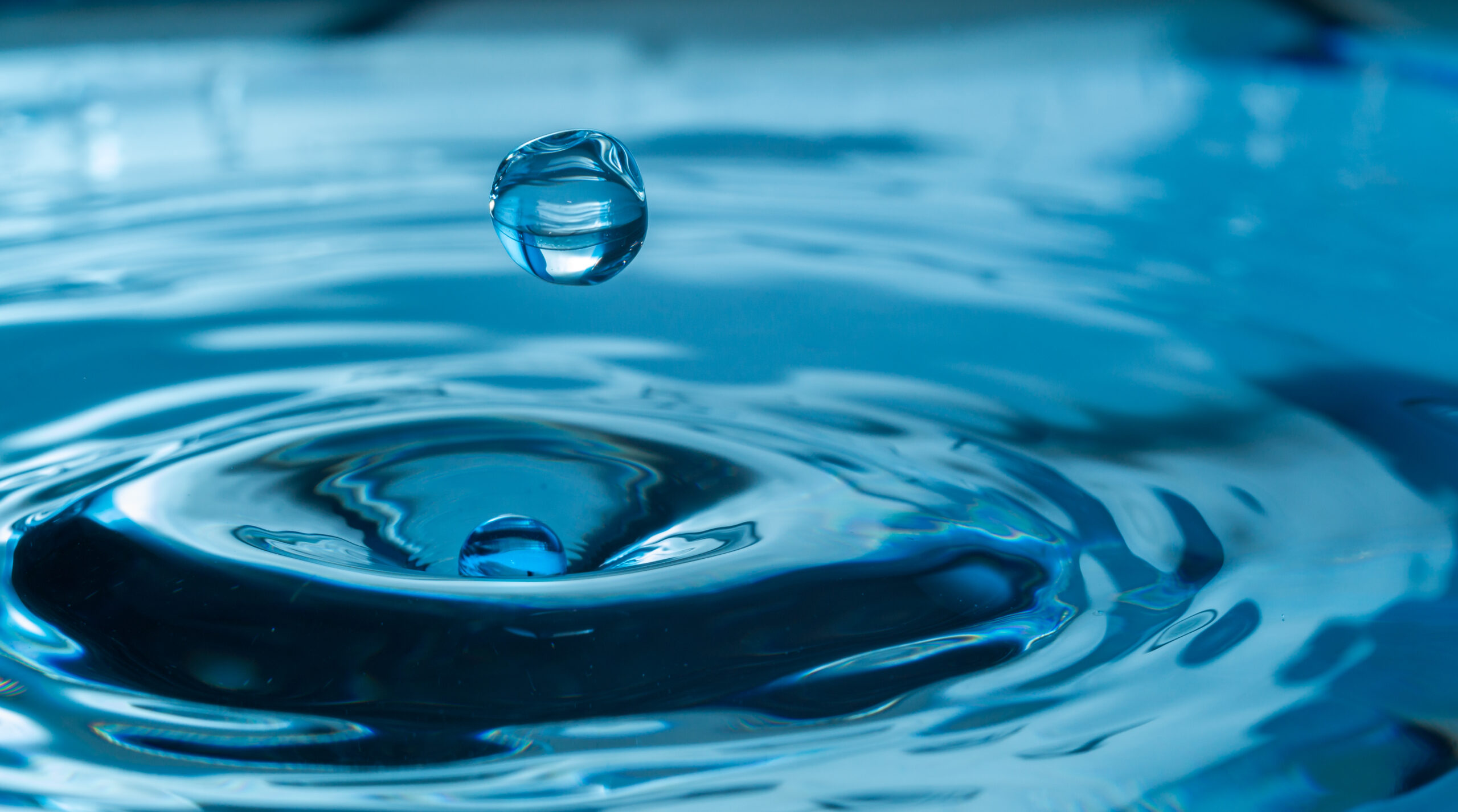 Water,Drop,Splash,In,A,Glass,Blue,Colored